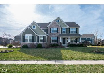 Inviting two-story home with a manicured lawn and a combination of brick and green siding at 2314 Angelina Way, Greenwood, IN 46143