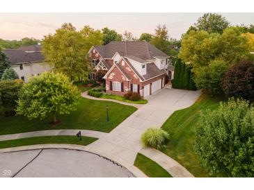 Aerial view of a brick two-story home with mature trees, manicured lawn and long driveway at 3727 Tributary Ct, Westfield, IN 46062