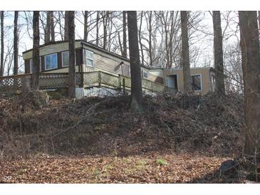 Exterior view of a manufactured home in a wooded area with a deck at 4478 W County Road 125 S, Greencastle, IN 46135