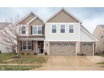 Charming two-story home with three-car garage, brick accents, and welcoming front porch at 6345 Meadowview Dr, Whitestown, IN 46075