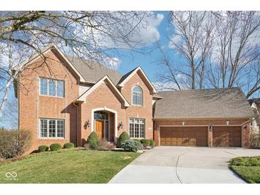 Beautiful brick home featuring an attached three-car garage and manicured lawn at 6516 Shamel Dr, Indianapolis, IN 46278