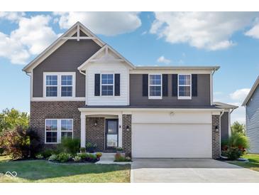 Charming two-story home featuring a brick and gray facade, with an attached two car garage and manicured front lawn at 9723 Violet Cir, Indianapolis, IN 46239