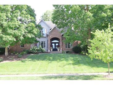 Beautiful home featuring a well-maintained lawn and mature trees providing shade at 9931 Woodlands Dr, Fishers, IN 46037