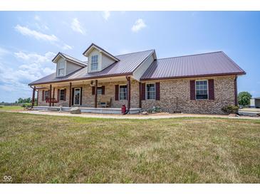 Charming brick home with a metal roof, covered porch, dormers, and a spacious front yard at 3777 S 300 E, Anderson, IN 46017