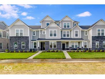 Beautiful townhome exterior featuring well-manicured landscaping and charming architectural details with modern gray and brick accents at 5785 Cr W 750 N, McCordsville, IN 46055