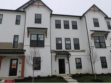 Charming townhome with white exterior, black trim, and manicured landscaping offers modern curb appeal at 7085 Pate Hollow Dr, Brownsburg, IN 46112
