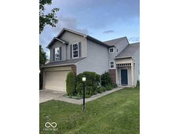 Charming two-story home with a two-car garage and a well-maintained lawn at 8033 Lake Tree Cir, Indianapolis, IN 46217