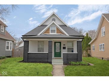 Charming home featuring a peaked gable roof, gray brick accents, and a freshly manicured front lawn at 843 N Oxford St, Indianapolis, IN 46201