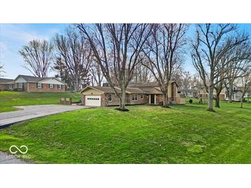 Charming single-story home featuring a well-maintained lawn, attached garage and beautiful landscaping at 9715 Mallery Dr, Noblesville, IN 46060