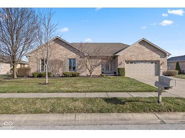 Charming one-story brick home with an attached two-car garage and manicured front lawn at 1114 Woodridge, Brownsburg, IN 46112