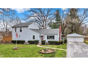 Charming two-story home with well-maintained lawn, complemented by a detached two car garage and mature trees at 207 E Ohio St, Mooresville, IN 46158