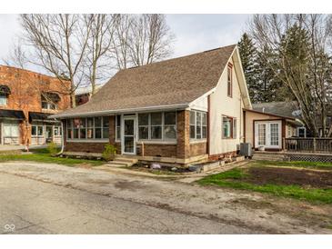 Charming home featuring brick and siding, with a sunroom and well-maintained landscaping at 4610 W 72Nd St, Indianapolis, IN 46268