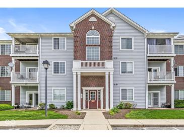 Three-story condo building with multiple balconies, brick accents, and well-maintained landscaping at 6231 Amber Creek Ln # 312, Indianapolis, IN 46237