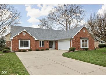 Charming brick home featuring an attached two car garage and well maintained lawn and driveway at 6628 Moss Cir, Indianapolis, IN 46237