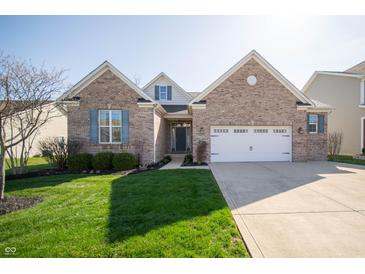 Charming brick home with a well-manicured lawn and attached two car garage, complemented by blue shutters at 7713 Imperial Eagle Dr, Zionsville, IN 46077
