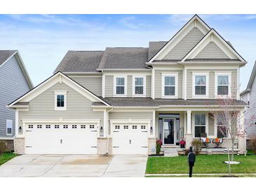Charming two-story home featuring a three car garage, covered entry, and manicured lawn at 15046 Sullivan Ln, Westfield, IN 46074