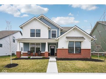 Charming two-story home with a cozy front porch, brick accents and manicured lawn at 2156 W 171St St, Westfield, IN 46074