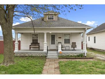 Charming home featuring a welcoming front porch with bench seating and a well-maintained lawn at 2709 S Mcclure St, Indianapolis, IN 46241