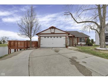 Charming home featuring a two-car garage, inviting deck and beautiful landscaping creating a welcoming curb appeal at 3701 Dorval Pl, Indianapolis, IN 46228