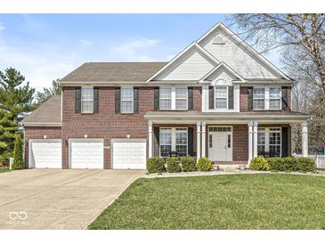 Charming brick two-story home with a three-car garage and inviting front porch at 3998 Jonathan Rdg, Columbus, IN 47201