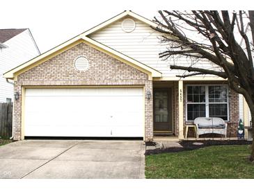Charming single-Gathering home with brick facade, attached two-car garage, and well-maintained front lawn at 5437 Powder River Ct, Indianapolis, IN 46221
