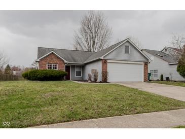 Charming single-story home featuring a brick and gray exterior with an attached two-car garage at 7352 Crickwood Pl, Indianapolis, IN 46268