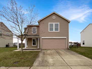 Charming two-story home with neutral siding, attached garage, and well-manicured lawn at 10719 Crackling Dr, Indianapolis, IN 46259