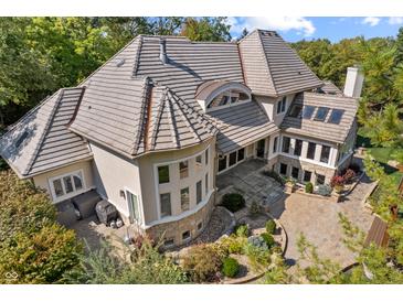 View of the back of home, displaying patio, beautiful landscaping, and stone and stucco accents at 10821 Club Point Dr, Fishers, IN 46037