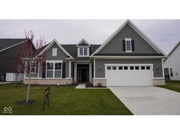 Charming home featuring gray siding, white trim, and a well-manicured front lawn and a two car garage at 1274 Clairet, Westfield, IN 46074