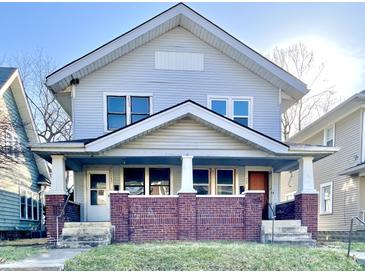Traditional two-story home featuring a symmetrical facade with a covered porch and brick support columns at 1425 N Lasalle St, Indianapolis, IN 46201