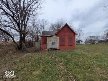 An exterior view of a derelict, boarded-up home, in need of significant repair at 1724 Sheldon St, Indianapolis, IN 46218