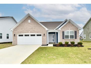 Charming brick home with a two-car garage, well-maintained lawn and nice landscaping at 1803 Jackson St, Fortville, IN 46040