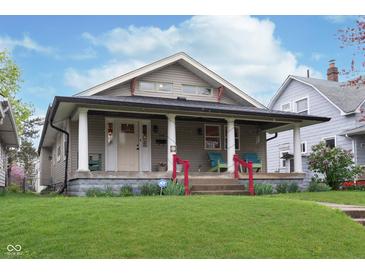 Charming home featuring a covered front porch, well-manicured lawn, and colorful landscaping, creating a welcoming curb appeal at 518 N Emerson Ave, Indianapolis, IN 46219