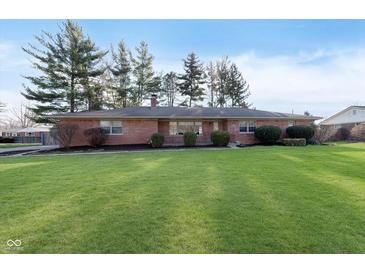Charming brick ranch home featuring a well-manicured lawn and mature trees at 6407 Brokenhurst Rd, Indianapolis, IN 46220