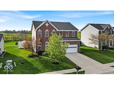Beautifully landscaped two-story home with a brick facade, green lawn, and spacious driveway at 6862 School Branch Dr, Brownsburg, IN 46112