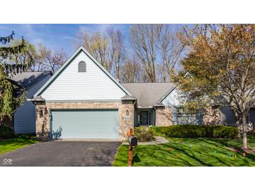 Charming single-story home with brick facade, light blue accents, and an attached two-car garage at 7616 Newport Bay E Dr, Indianapolis, IN 46240