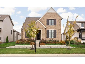 Charming brick home with manicured lawn, tasteful landscaping, and classic architectural details at 15628 Allegro Dr, Westfield, IN 46074