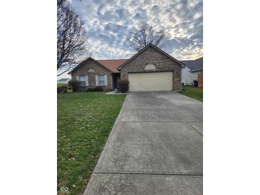 Charming brick home featuring an attached two-car garage and a well-manicured lawn at 5233 Birmingham Dr, Indianapolis, IN 46235