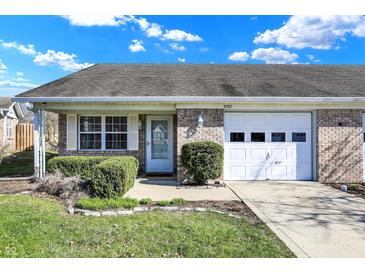 Charming single-story brick home featuring an attached garage and manicured landscaping at 5737 Misty Ridge Cir, Indianapolis, IN 46237