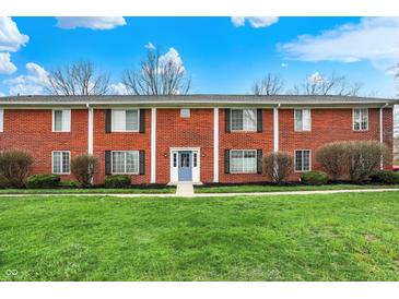 Charming brick townhome with a well-manicured lawn and inviting blue front door at 6515 Park Central Way # B, Indianapolis, IN 46260