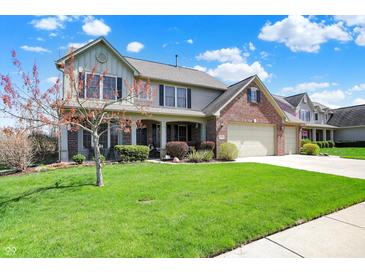 Charming two-story home with a well-manicured lawn and mature trees at 7233 Capel Dr, Indianapolis, IN 46259