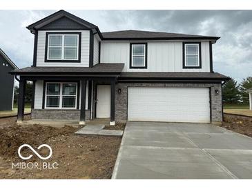 Charming two-story home with stone accents, a two-car garage, and a well-manicured lawn at 7549 Big Bend Blvd, Camby, IN 46113