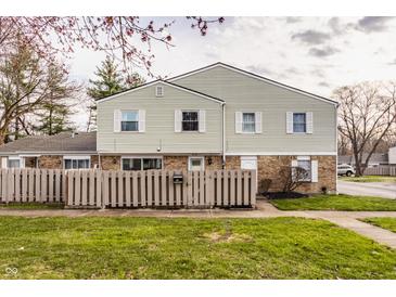 Inviting exterior of a townhome with charming fence and well-maintained lawn at 8336 Woodall Dr # Kr, Indianapolis, IN 46268