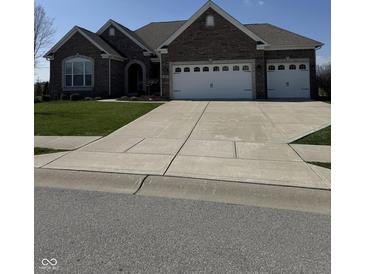 Charming single-story brick home with a spacious three-car garage and well-manicured lawn at 15085 Thoroughbred Dr, Fishers, IN 46040