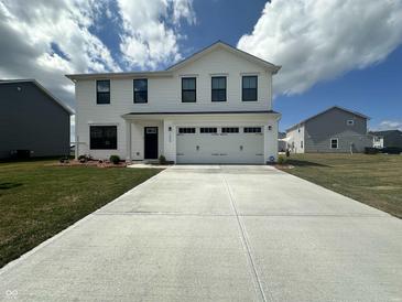 Beautiful two-story home boasts a manicured lawn, driveway, and charming curb appeal at 1862 Cascades Dr, Greenfield, IN 46140