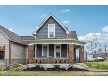 Charming two-story home with gray siding, brick foundation and inviting front porch at 234 S State Ave, Indianapolis, IN 46201