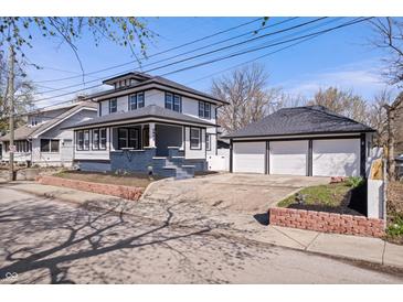 Charming two-story home features a spacious front yard, brick accents, and a detached three-car garage at 2920 E 11Th St, Indianapolis, IN 46201