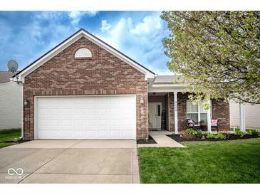 Charming brick home featuring an attached garage, well-manicured lawn, and welcoming front porch at 3168 Lodgepole Dr, Whiteland, IN 46184
