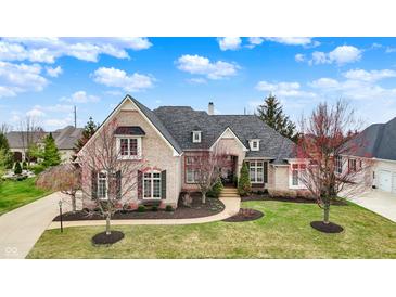 Stunning brick home featuring professional landscaping, a gray roof and an attached three car garage at 3629 Pete Dye Blvd, Carmel, IN 46033