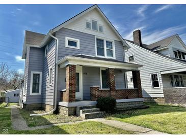 Charming two-story home with brick and gray siding under a blue sky, showcasing its curb appeal at 418 N Drexel Ave, Indianapolis, IN 46201